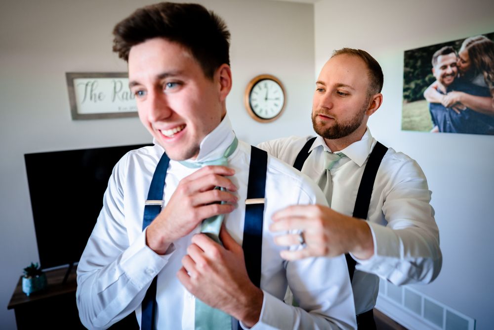 Groomsmen in white shirts and formal attire getting ready for the ceremony.