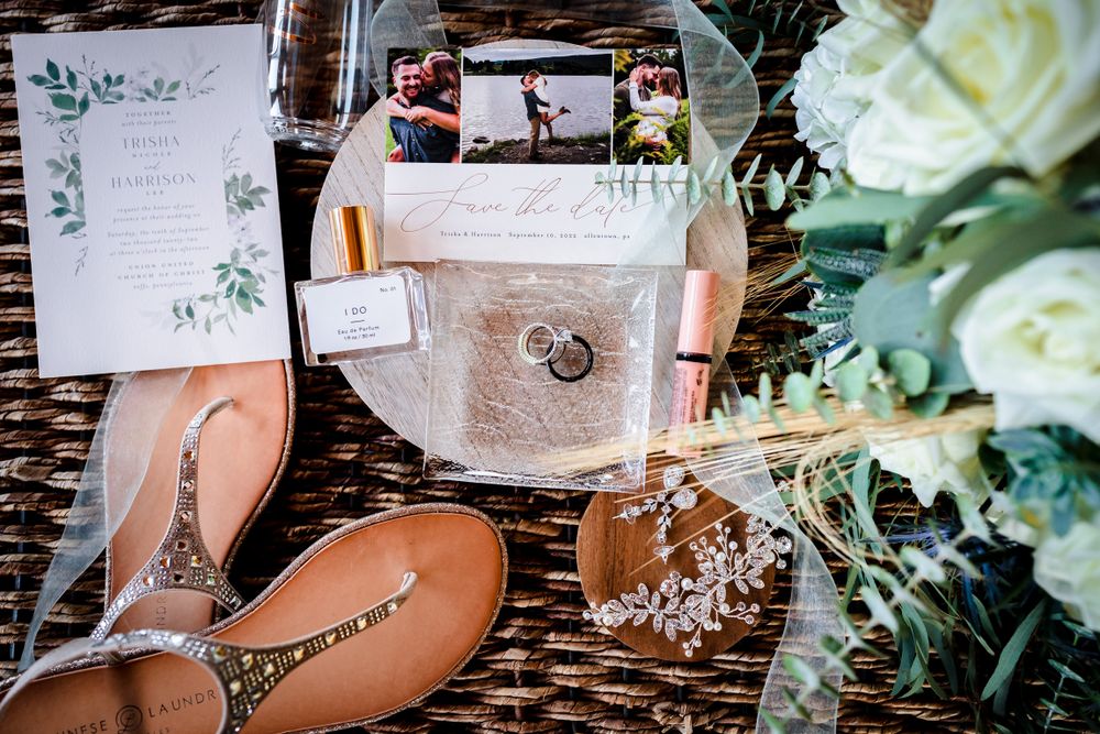 Wedding details including invitations, flowers and decorative elements on wooden surface.