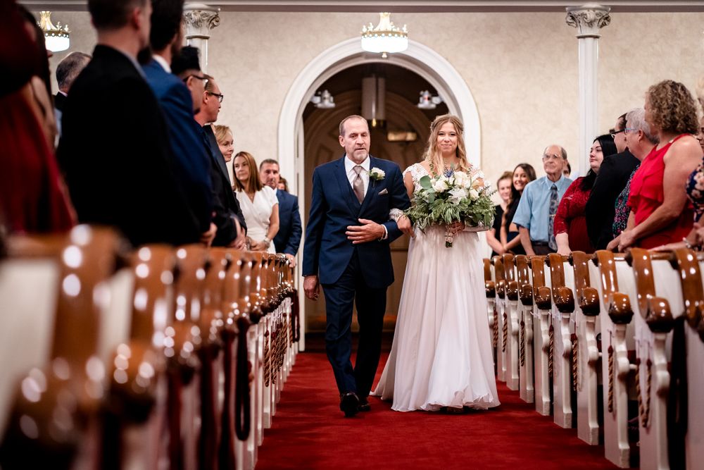 Church wedding ceremony with wooden pews and traditional architectural details.