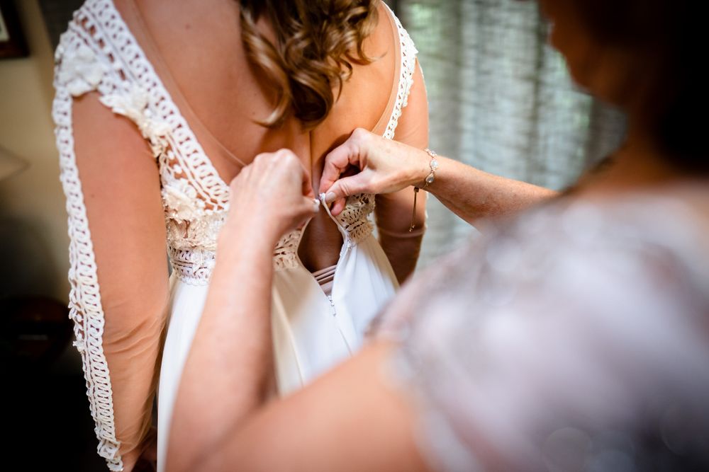 Close-up shot of a delicate lace wedding dress detail with intricate beading and embroidery.