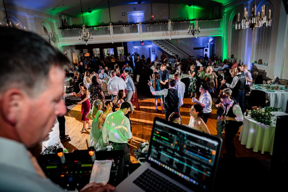 Wide angle view of wedding reception venue with green and blue accent lighting.