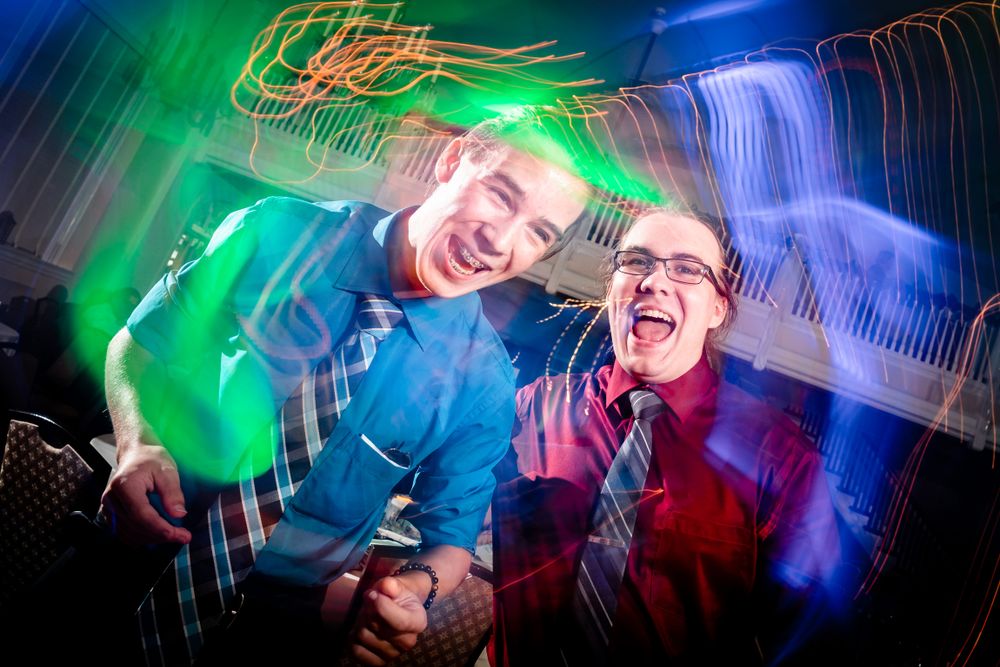 Dynamic long exposure shots of wedding reception dancing with light trails.