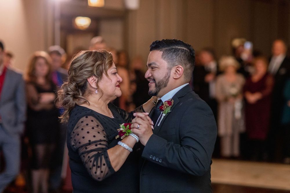 Emotional dance moment captured during wedding reception with guests watching in background.