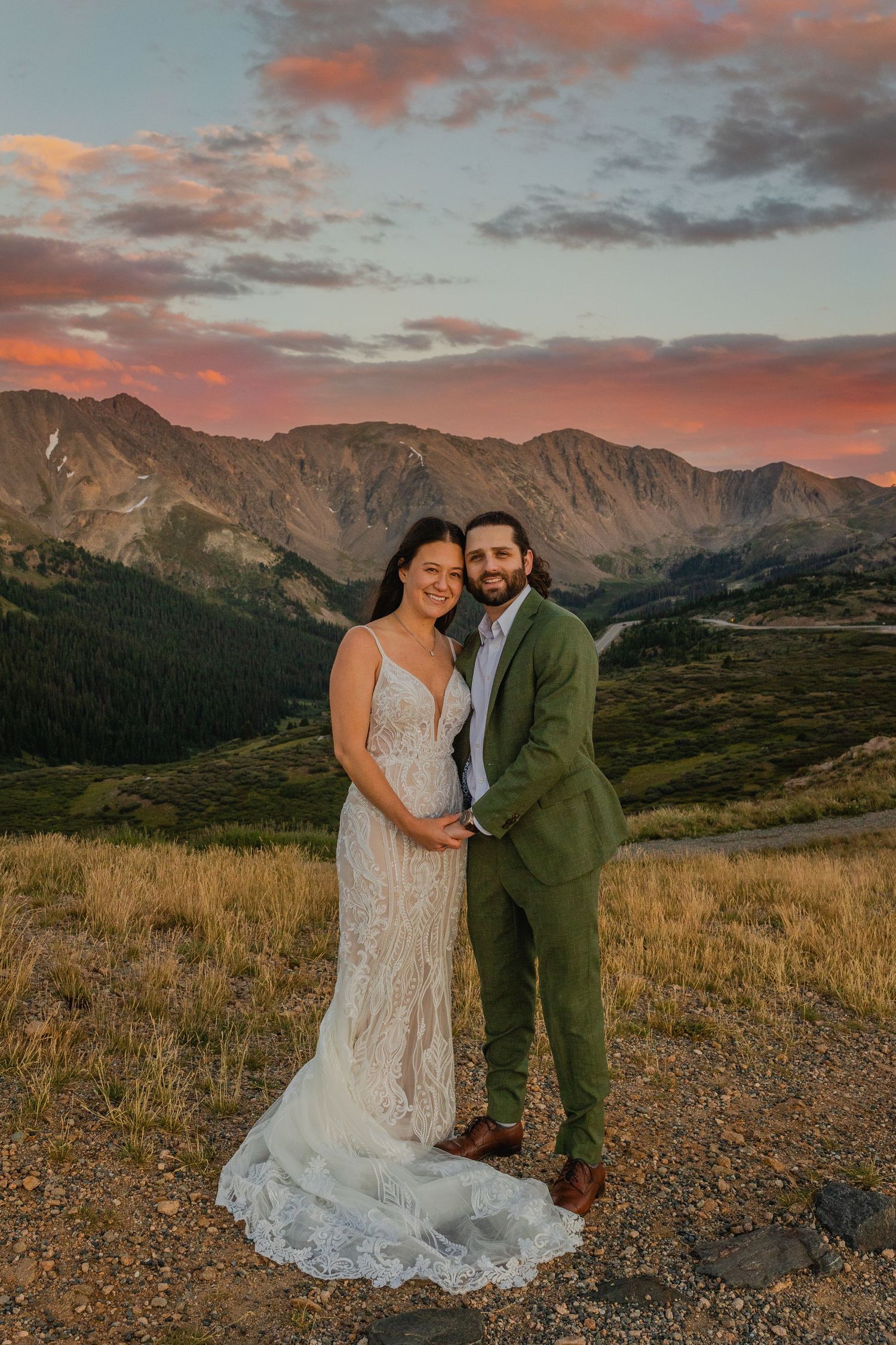 Bride and groom embrace with a stunning mountain backdrop on Loveland Pass, Colorado