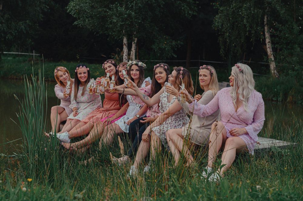 Group relaxing on blankets during an outdoor gathering in a natural setting.
