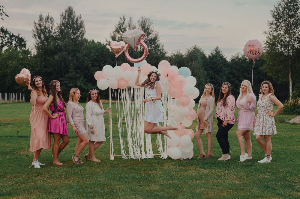 Pink-themed outdoor party with balloons and coordinated outfits in a garden setting.