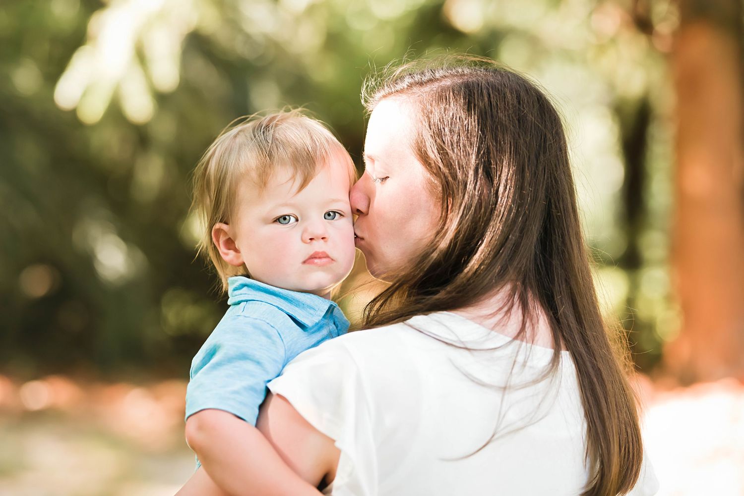 Sweet family interactions captured in a natural outdoor setting with soft lighting.