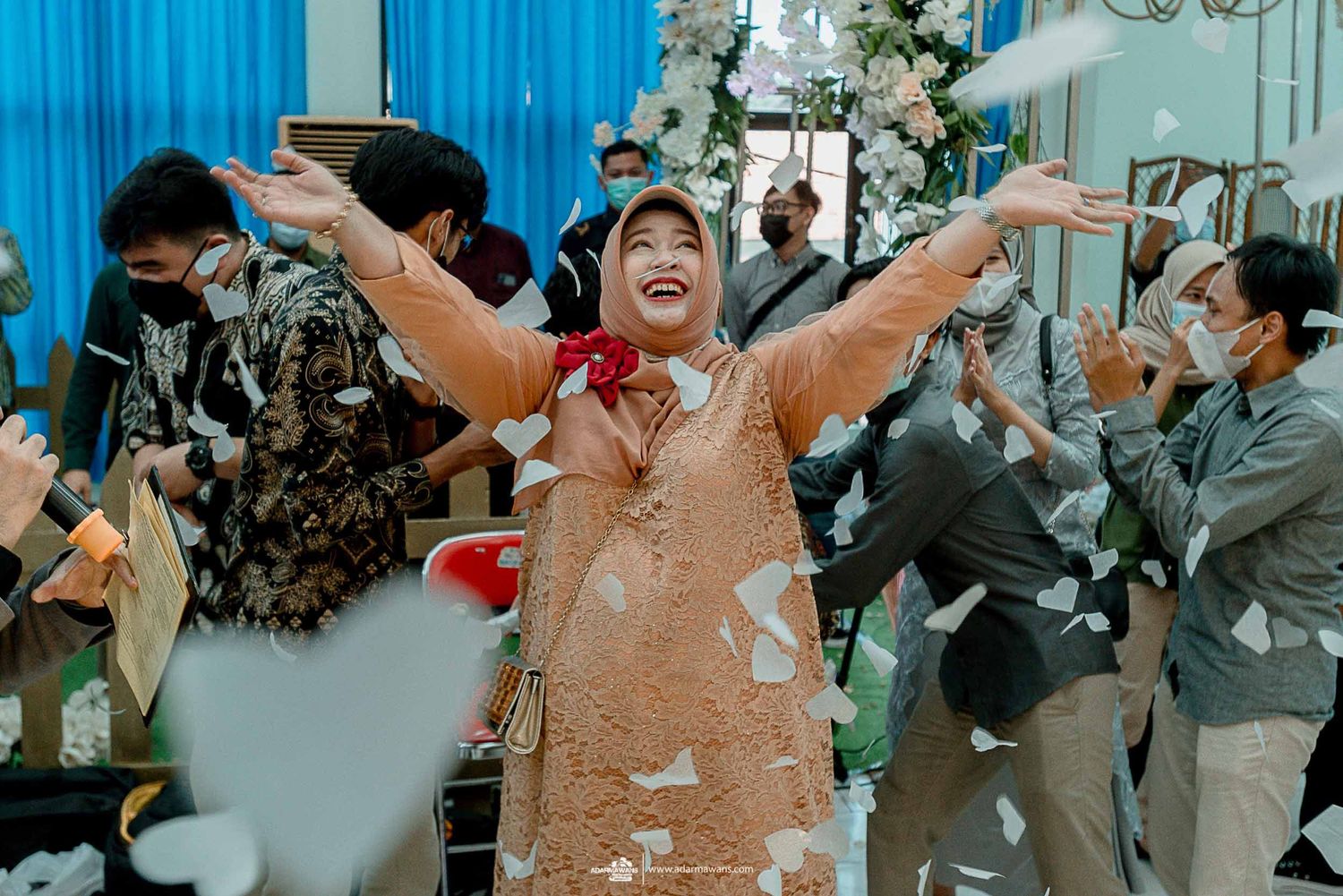 Celebratory moment with confetti during a wedding reception in a blue-themed venue.