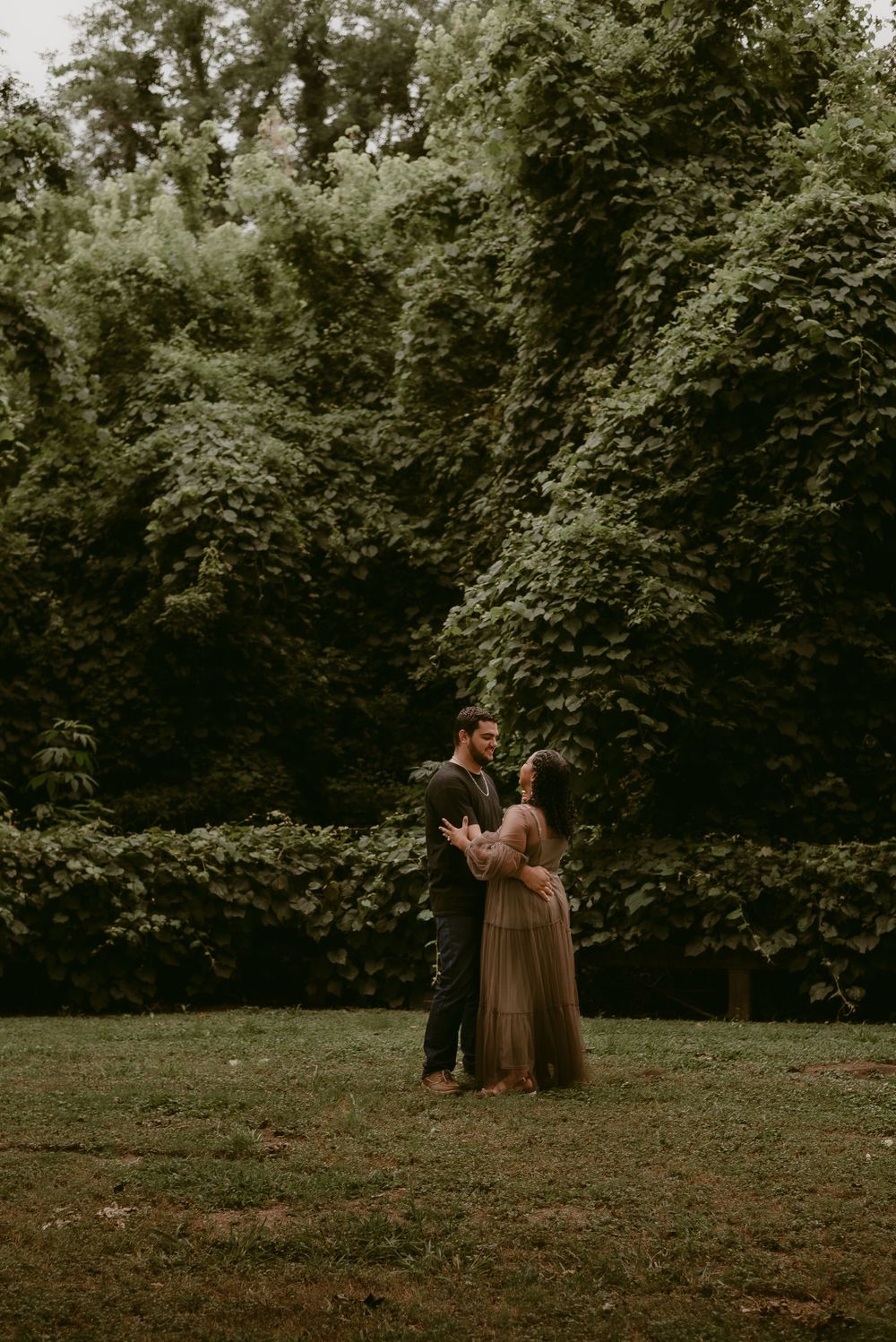 A couple shares a romantic dance in a scenic outdoor garden.