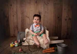 Rustic themed photo setup with vintage props and colorful Easter eggs on wooden background.