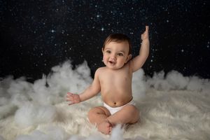 Dreamy portrait on white fluffy backdrop with starry night sky effect.