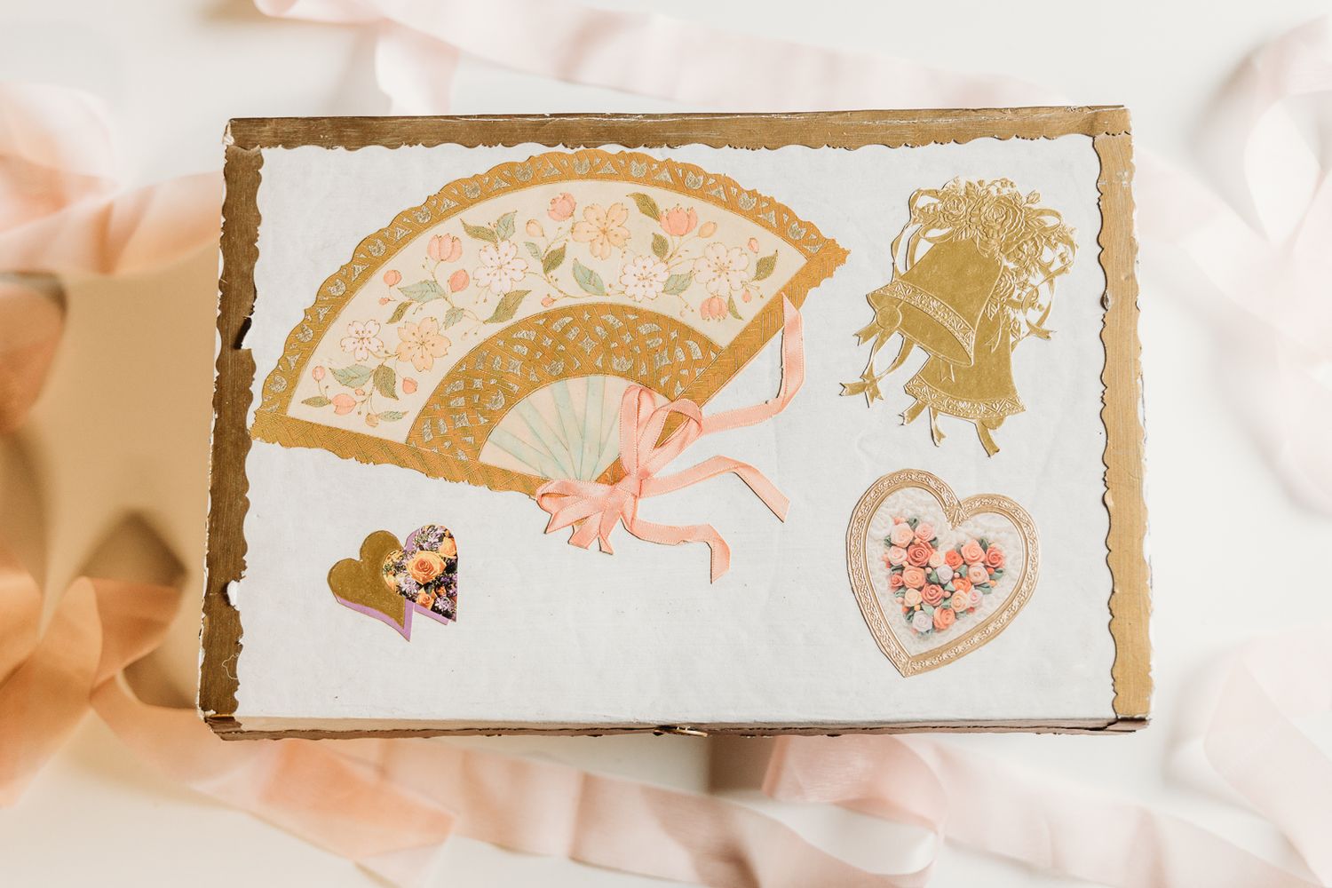 A decorative gold and pink greeting card featuring fan and heart motifs.
