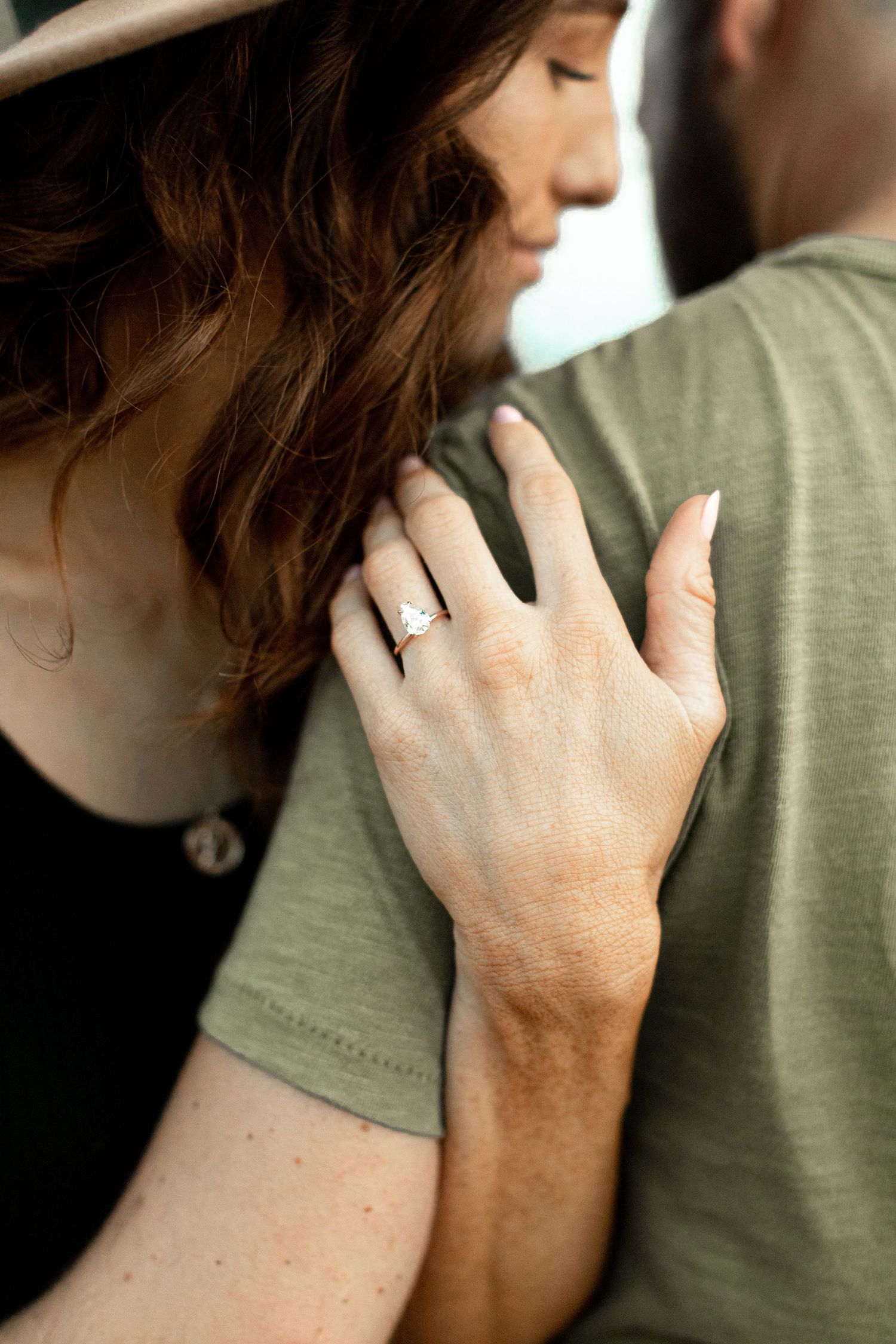 couple embraces showing engagement ring in orange county California