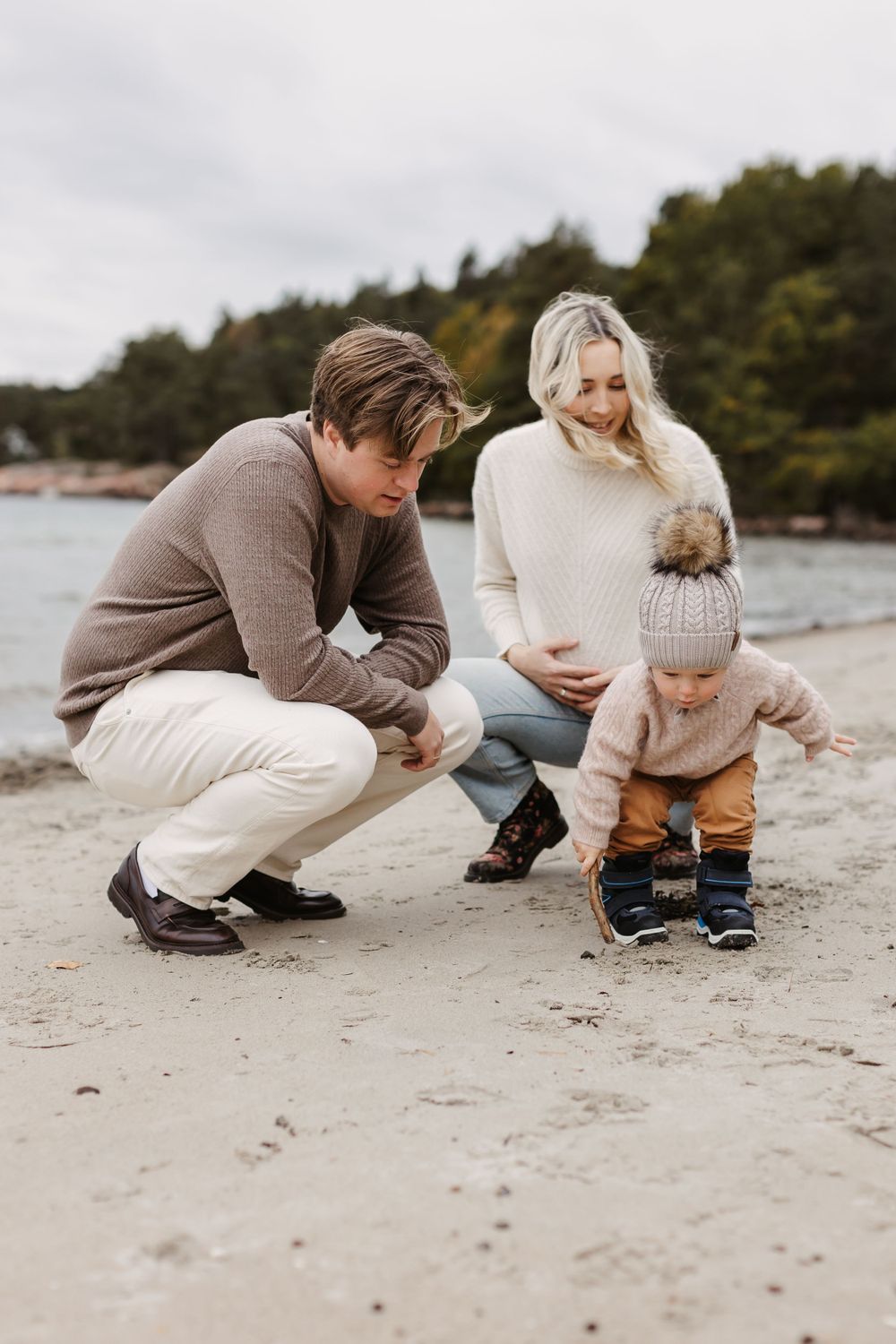 familie på tre på stranden, mamma er gravid