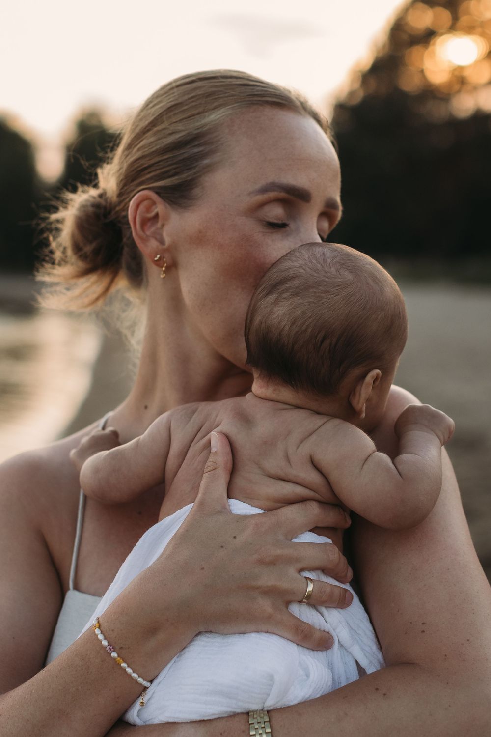 mor som holder baby nær inntil seg omgitt av varmt lys