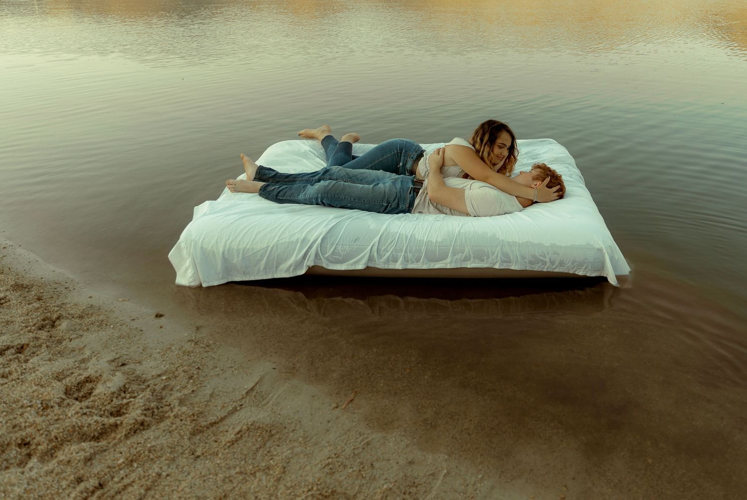 A couple floating on a mattress in water in a lake