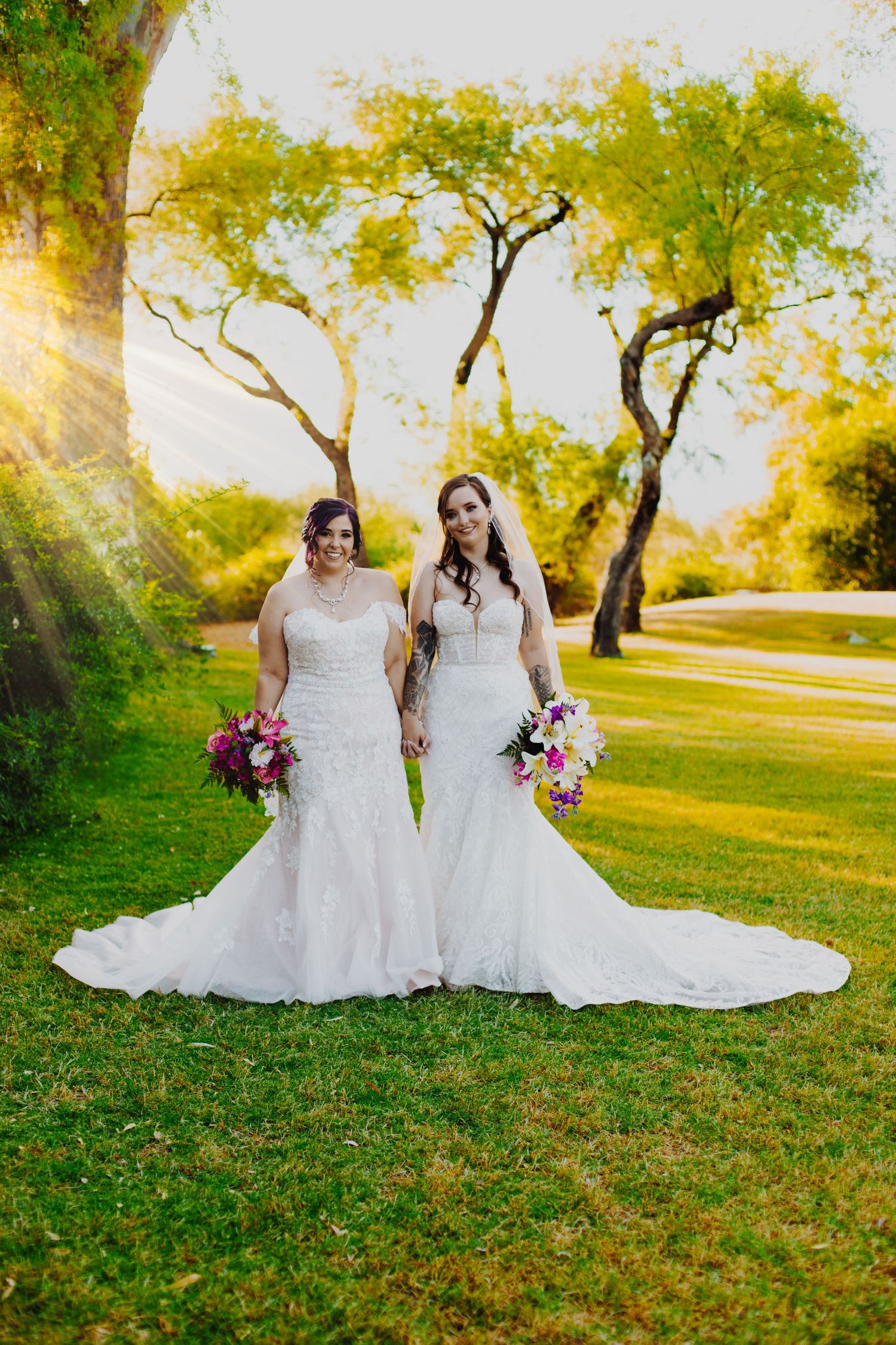Wedding portraits in a lush green garden with flowing white dresses and floral bouquets.
