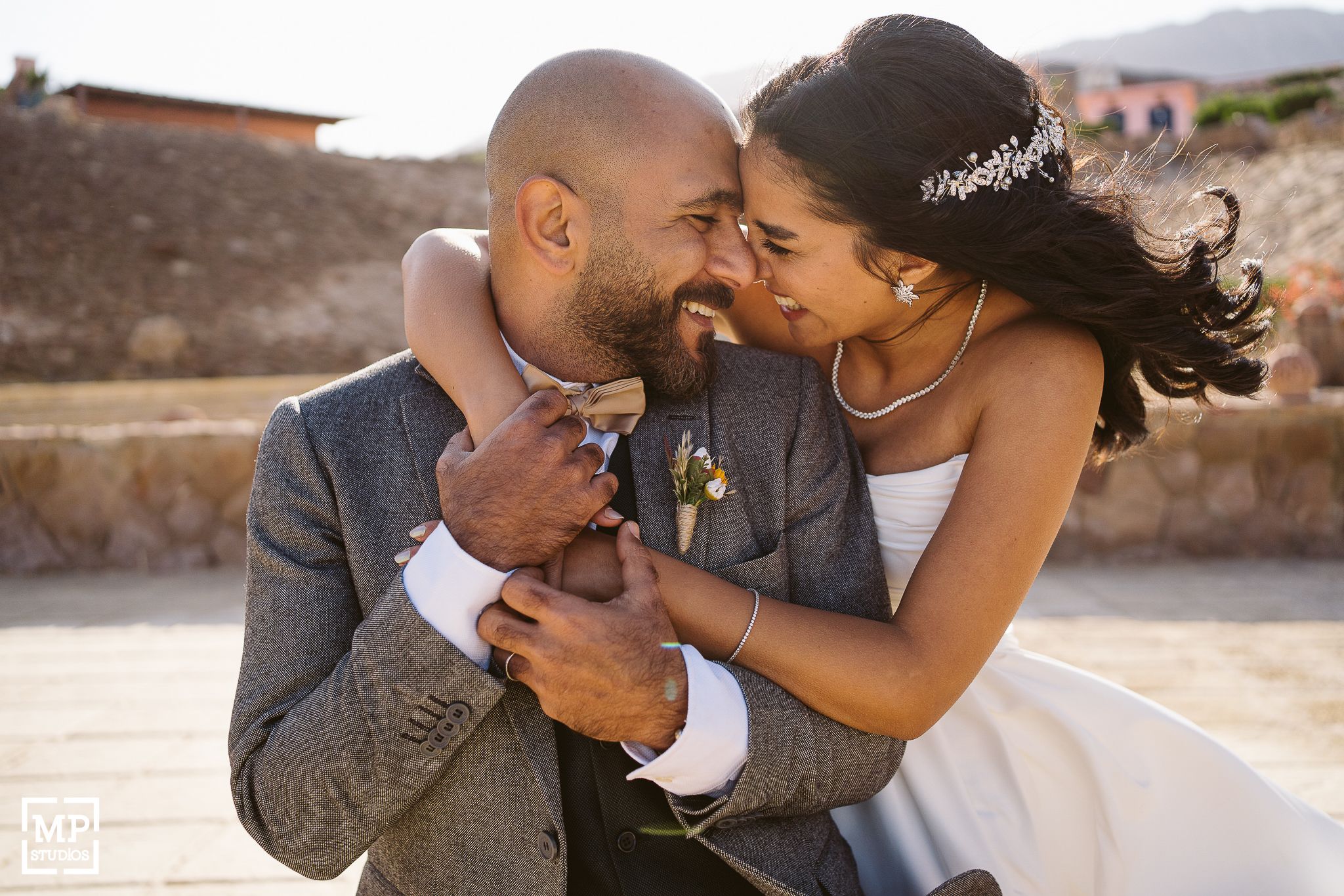 A couple sharing a joyful moment together during their wedding day outdoors.