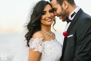 Romantic moment between newlyweds in formal wedding attire during outdoor photo session.