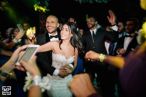 Wedding reception celebration with dancing and glowing lights in outdoor evening setting.