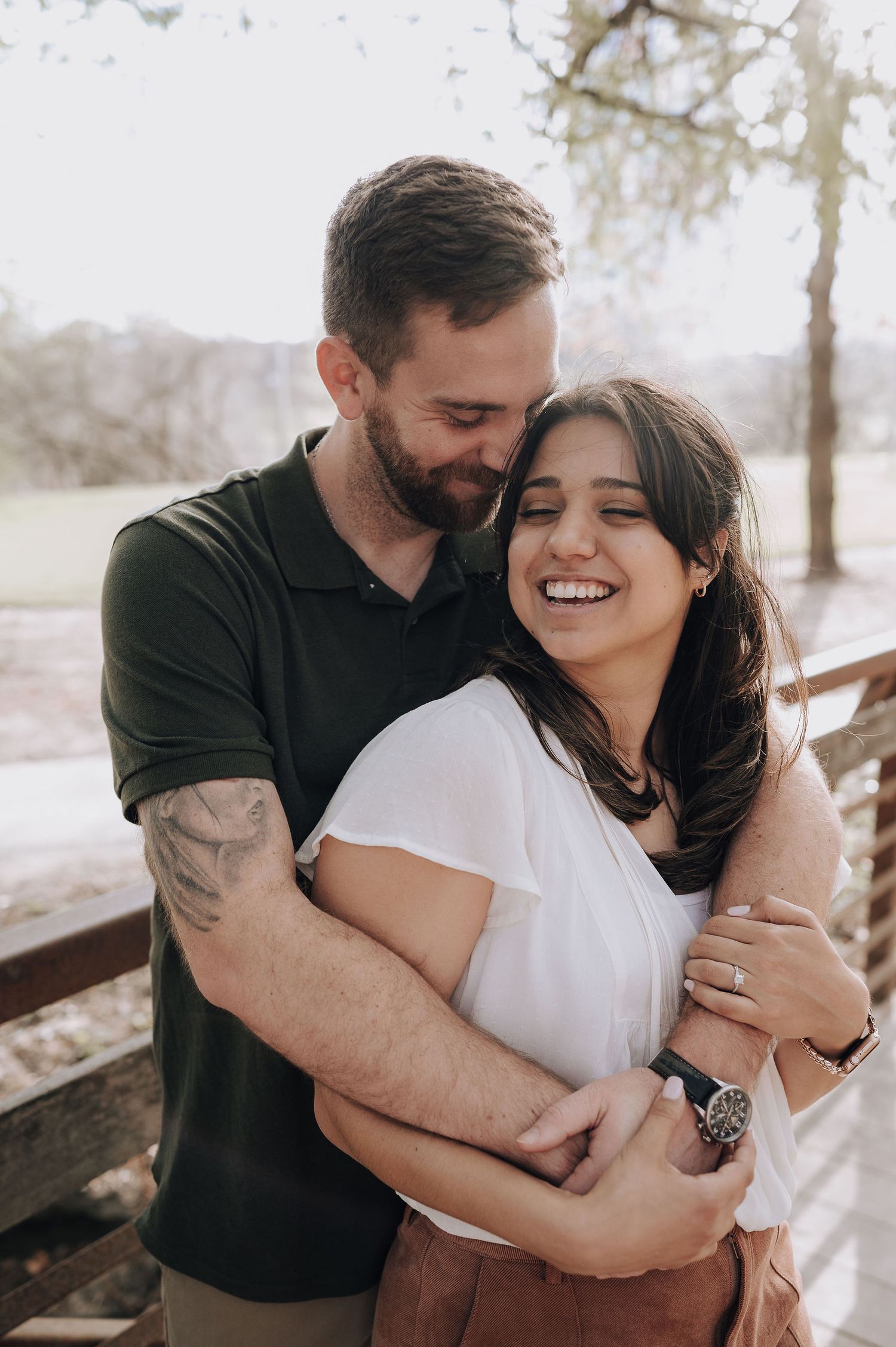 A loving couple shares a joyful moment during their engagement photos outdoors.