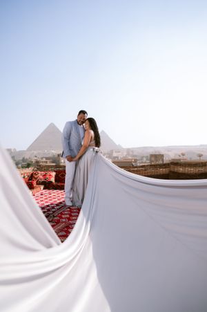 Romantic white fabric frames couple with pyramids of Giza in background.