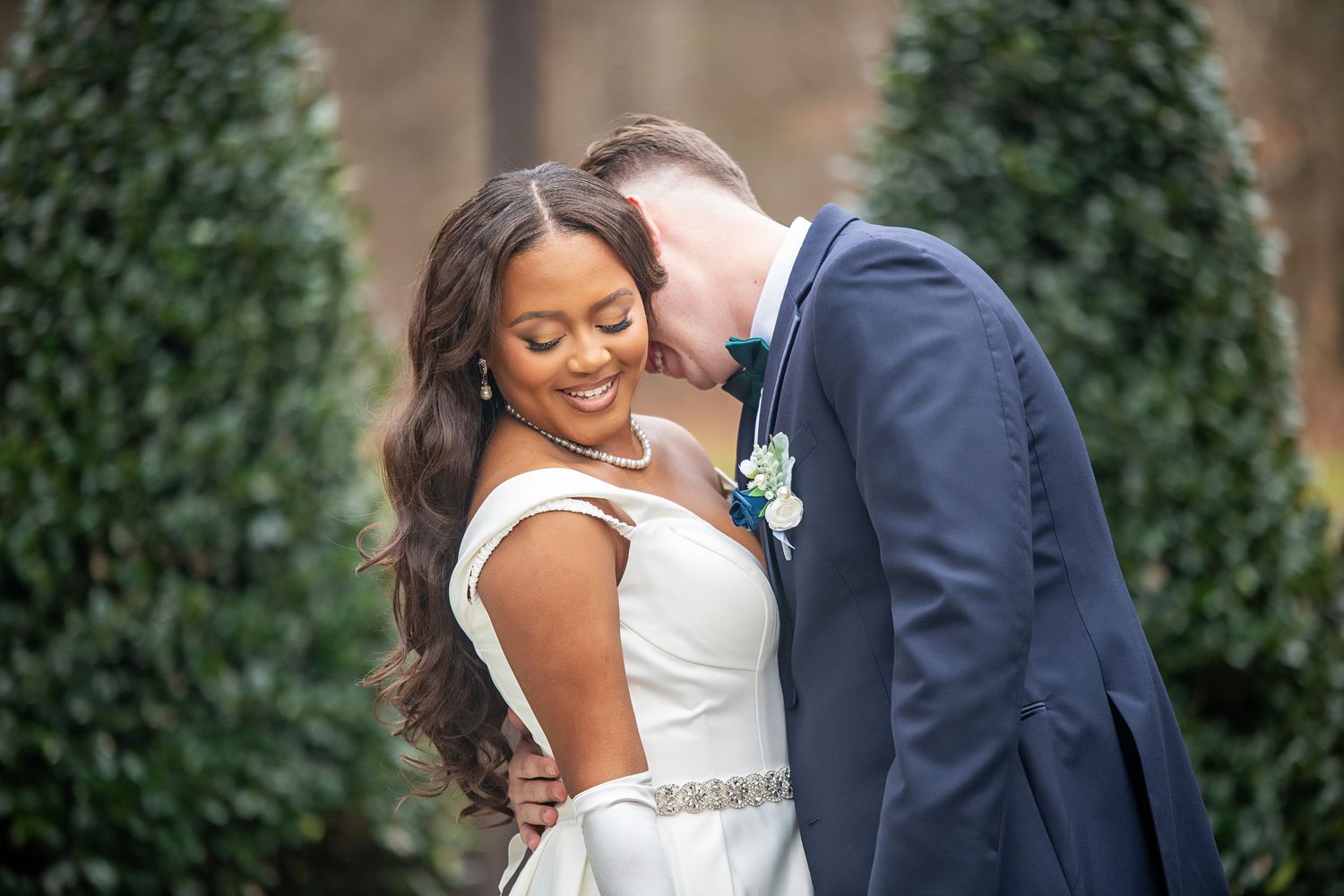 A joyful wedding moment captured with the couple laughing together outdoors.