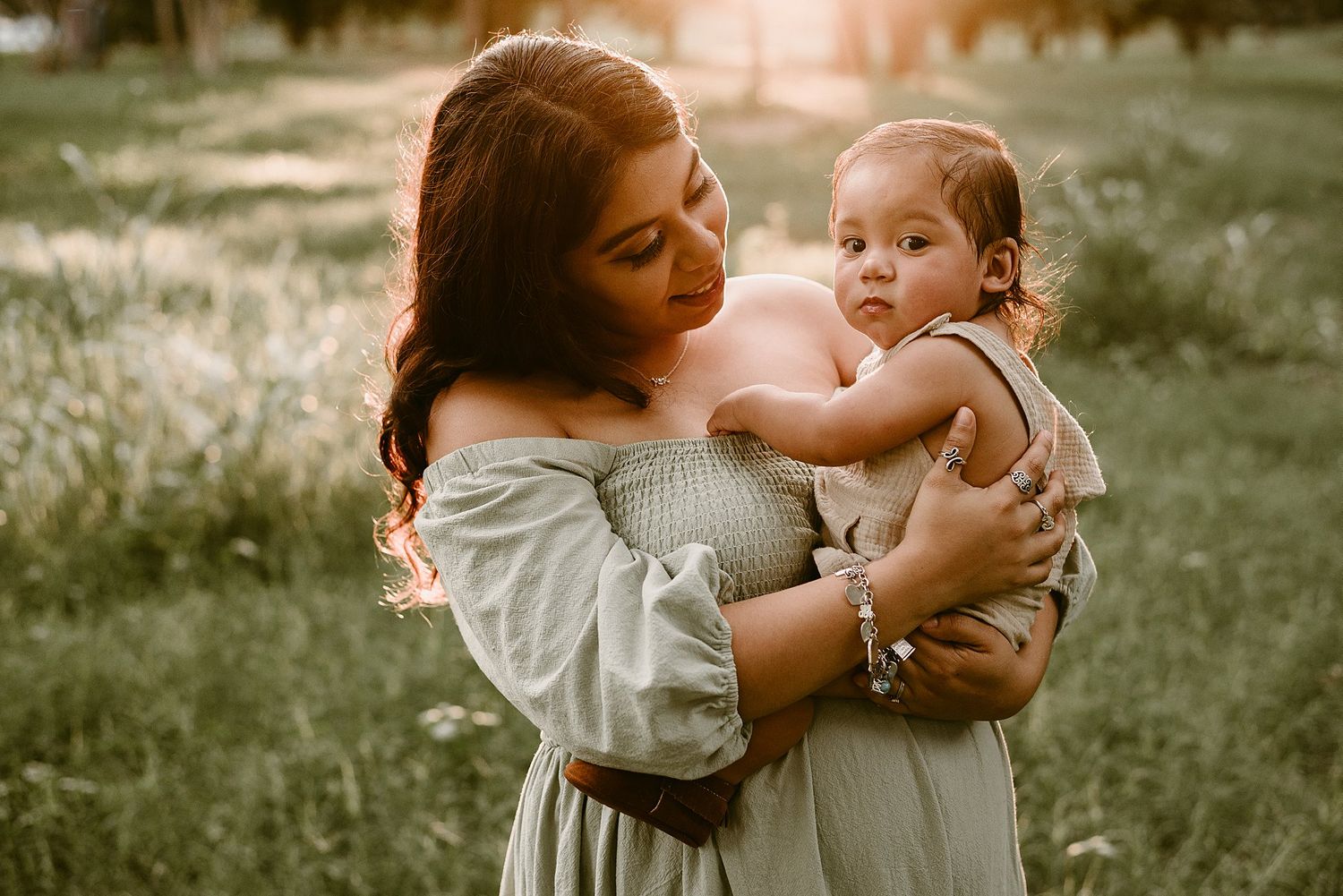 An intimate moment captured between a woman and child in warm sunset lighting.