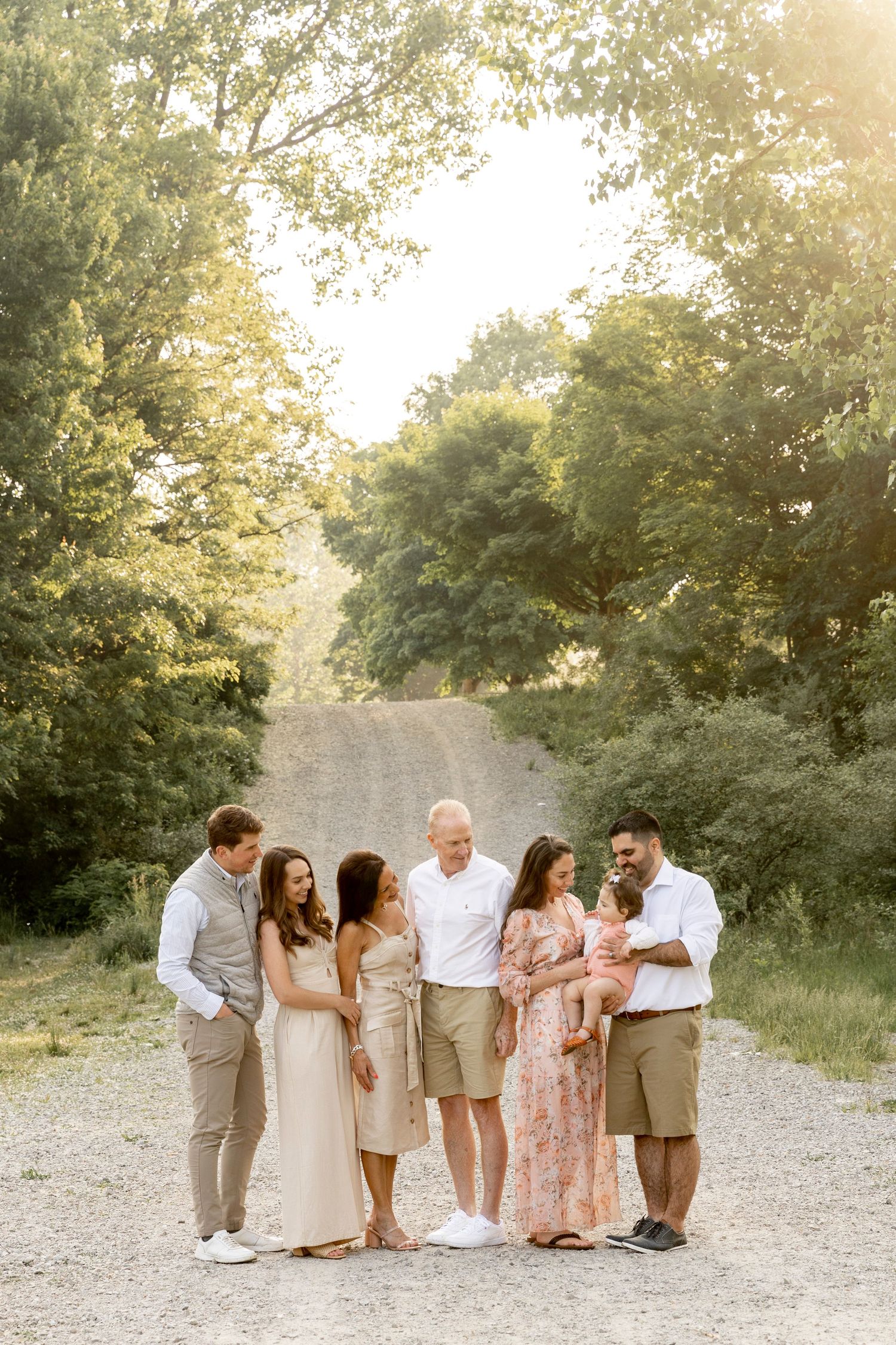 large family smiling at a baby wearing tans and pinks at river bends park