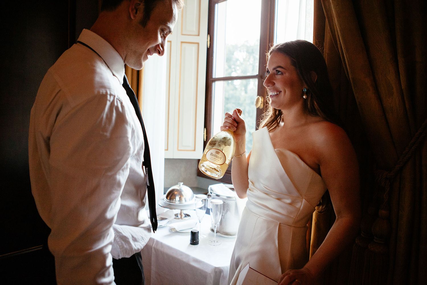 bride and groom with a bottle of wine at the Four Seasons Hotel in Florence Italy