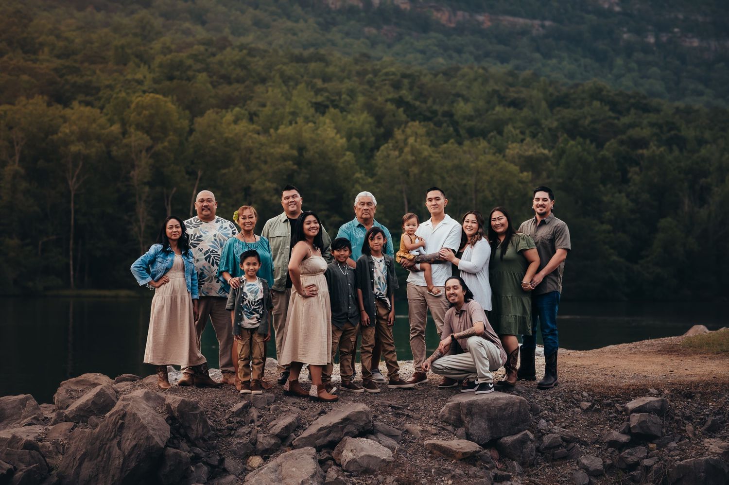 a large extended family of 15 groups together on a rock outcrop for family photos in Chattanooga