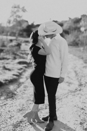 A black and white romantic portrait of a couple on a rural path.