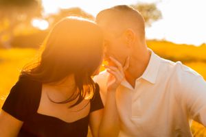 A couple sharing a sweet moment during sunset in a golden field.