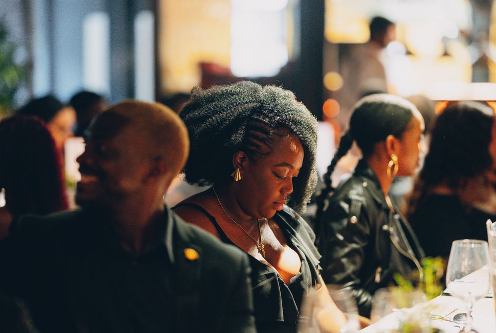 Guests enjoying a social gathering at a restaurant with warm ambient lighting.