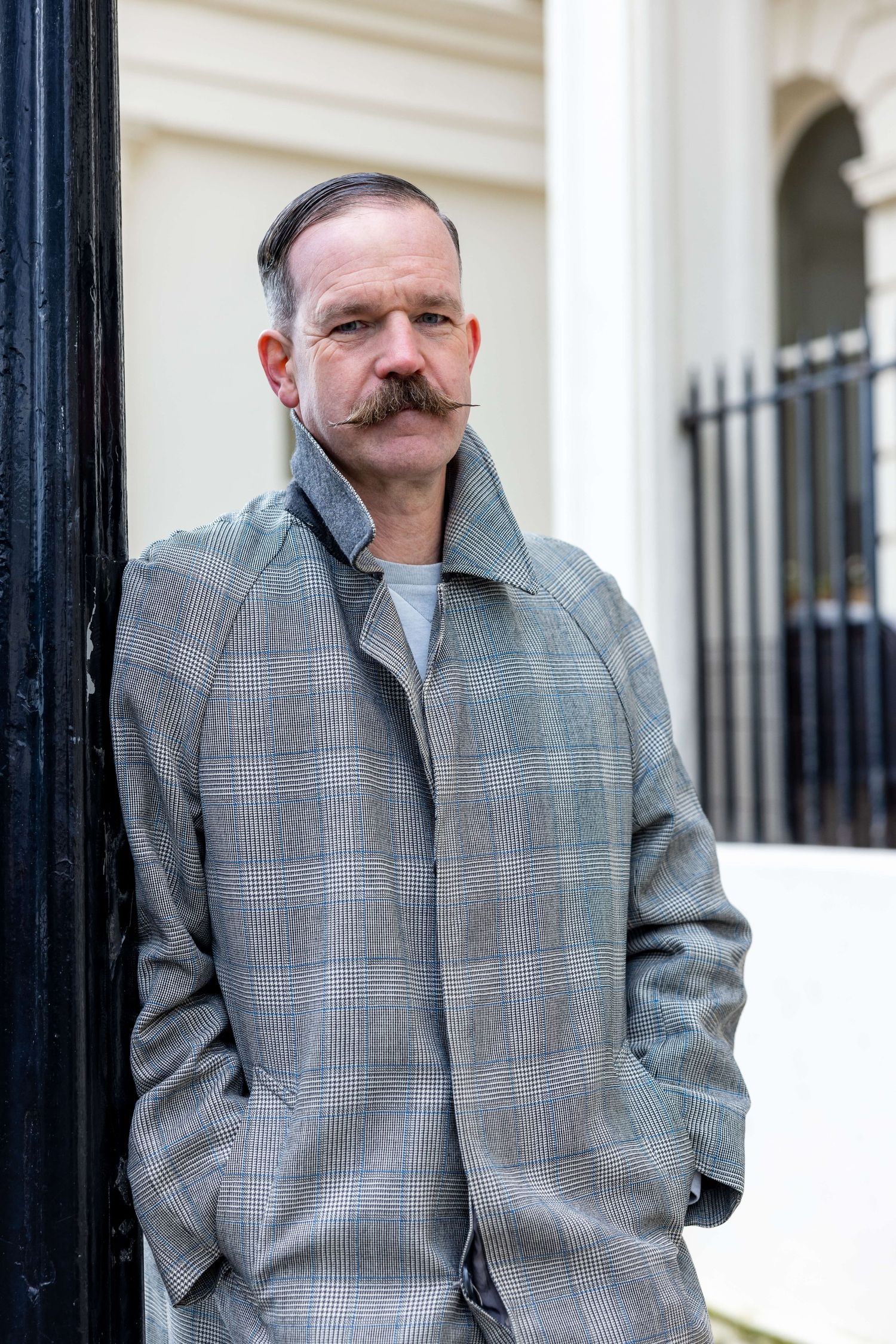 Close up of Dan leaning on lamppost in Hove looking dapper for his headshots