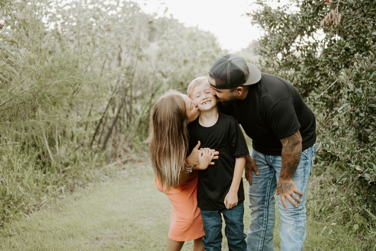 Family at Gemini springs park hugging at sunset with a garden of bushes