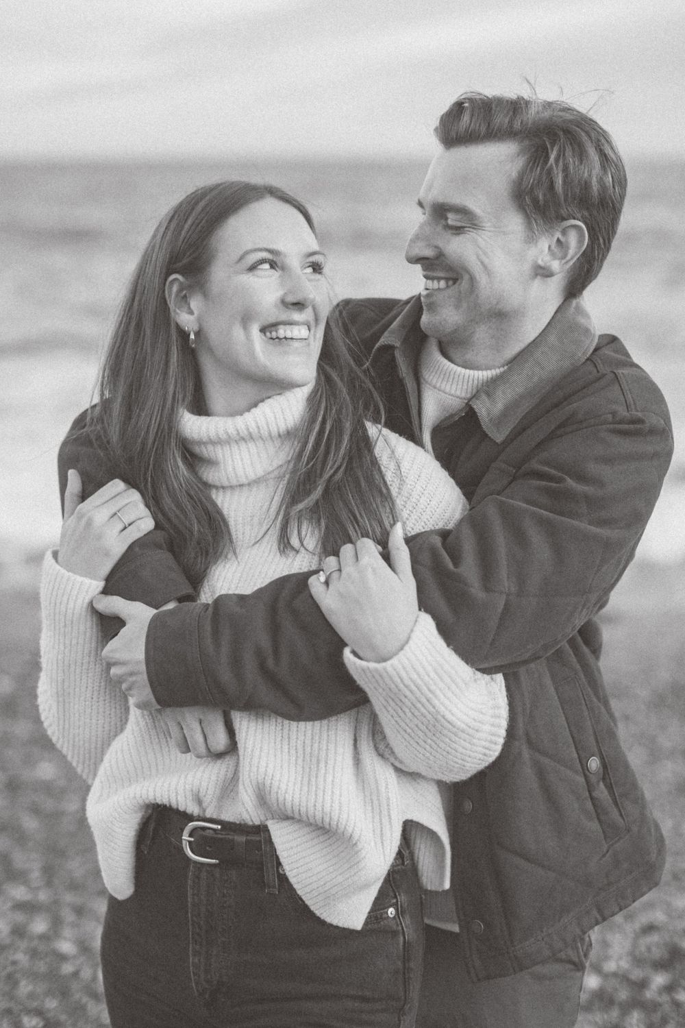A black and white portrait of a couple embracing on a beach in Montauk, Long Island, New York.