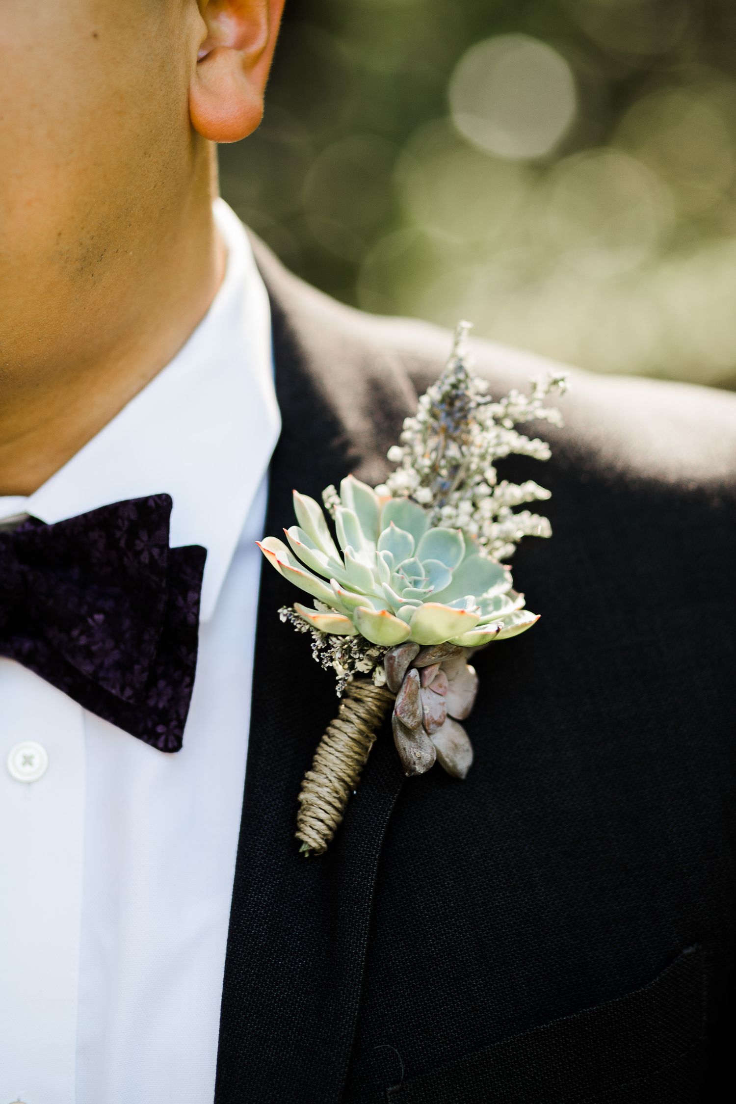 Closeup of groom's boutonnière of succulents by Hudson Valley photographer