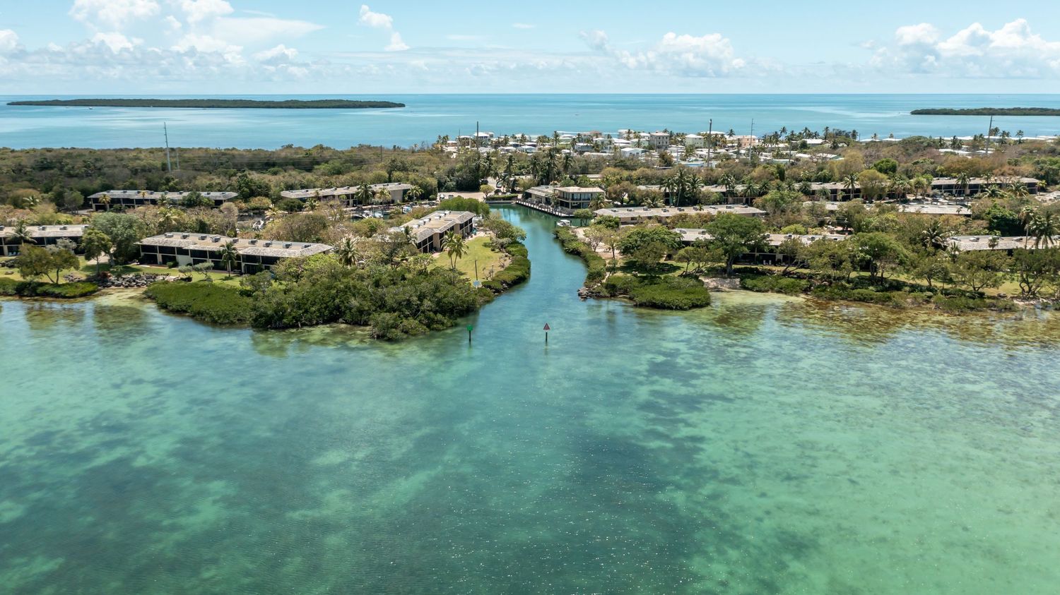Panoramic aerial view of tropical coastline with turquoise waters and urban development.