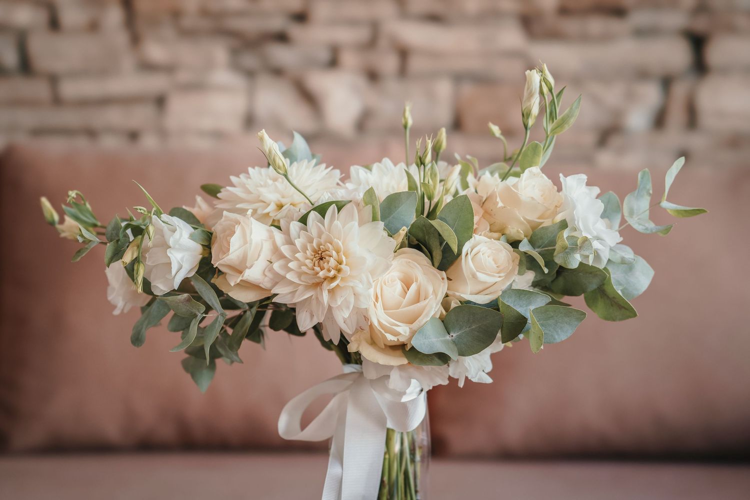 Elegant white and cream rose wedding bouquet with eucalyptus accents.