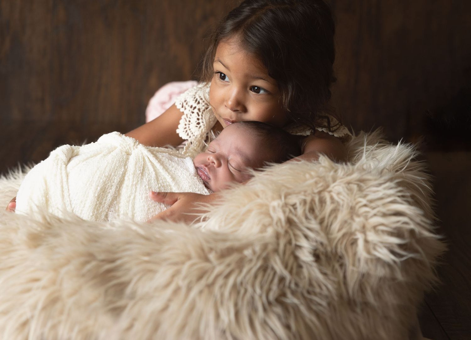 Intimate family portrait on furry backdrop featuring a gentle embrace.