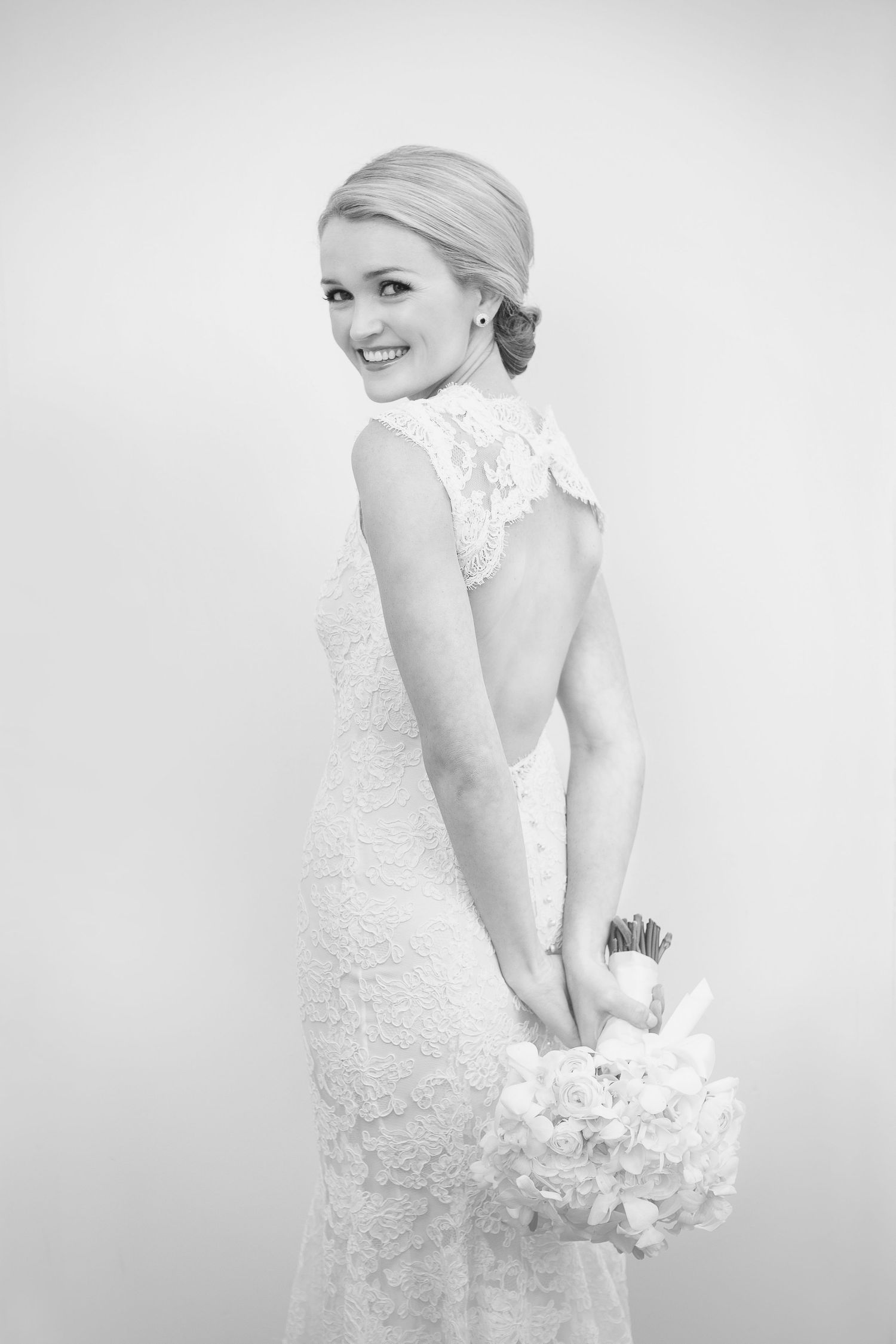 Elegant bridal portraits in white lace dress against light background.