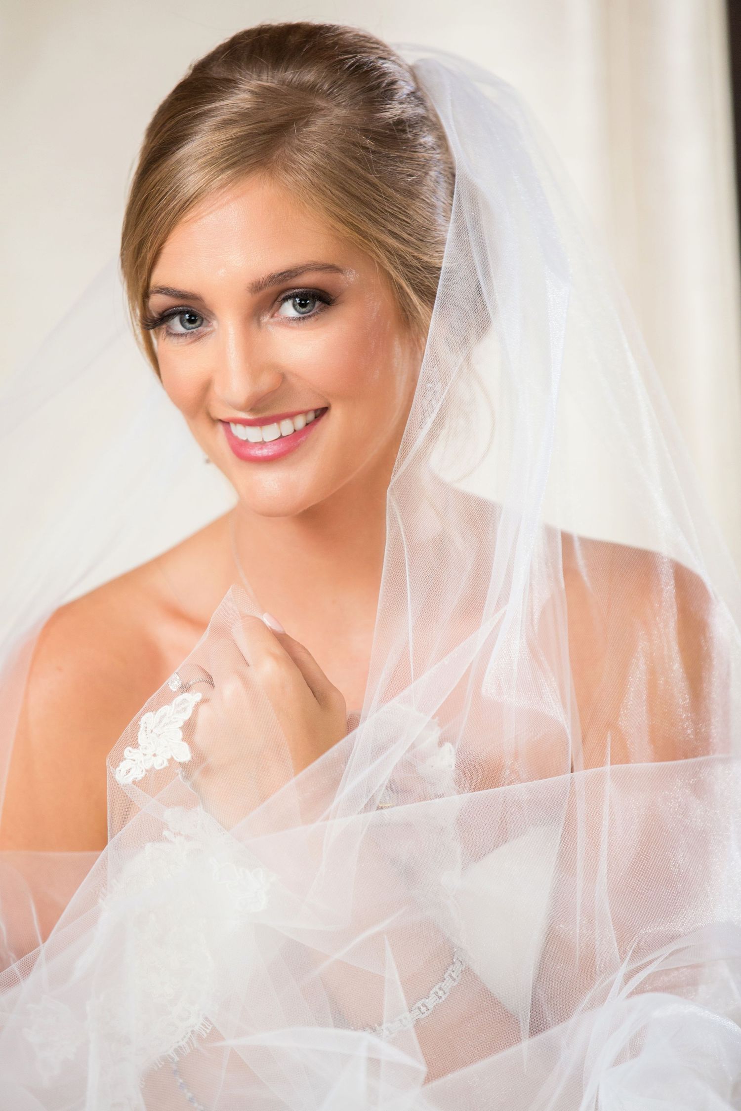 Soft, romantic bridal portraits feature delicate white veil details and classic wedding day styling.