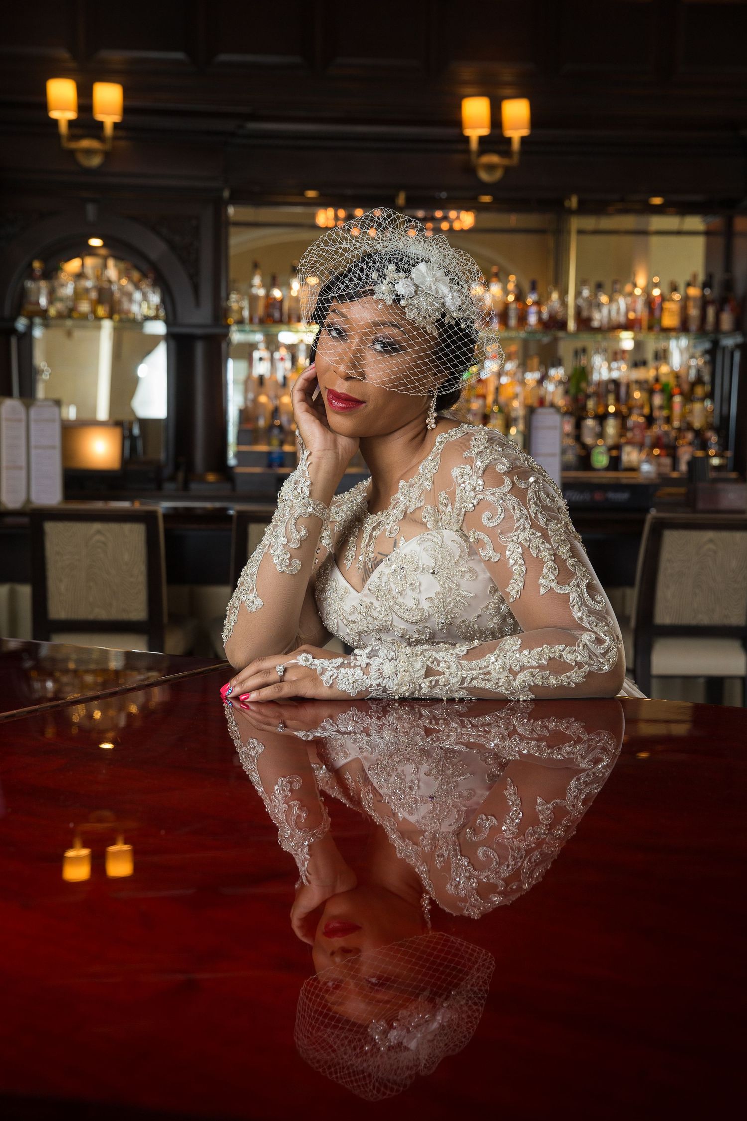 Elegant bridal portrait captured at a dimly lit bar with warm ambient lighting and romantic atmosphere.