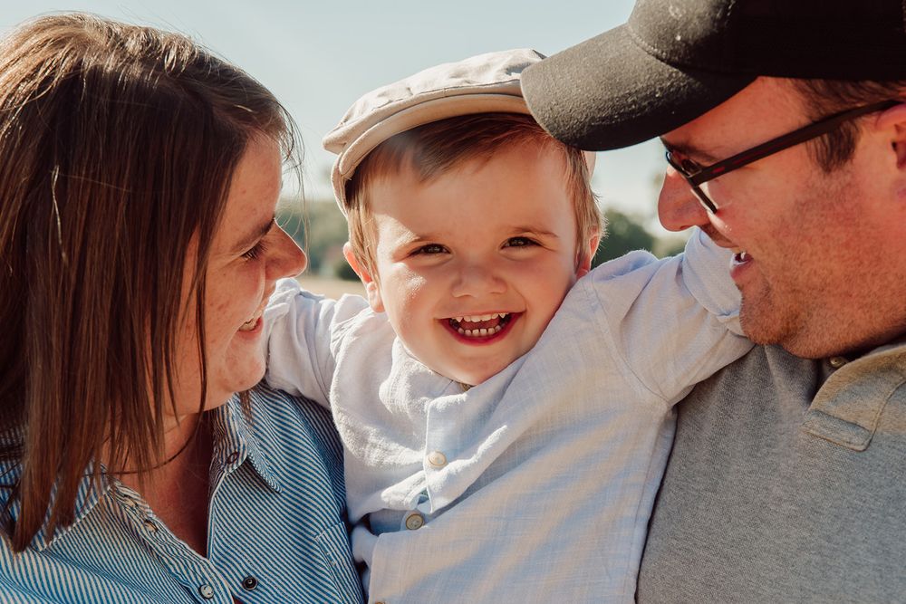 Kleine jongen samen met zijn mama en papa, in het graan aan het spelen