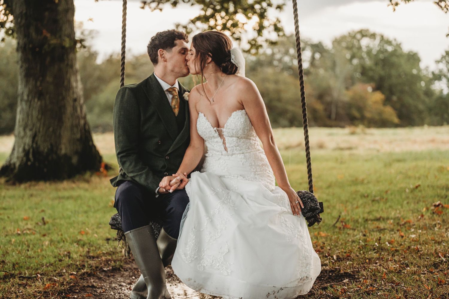Intimate moment shared on a wooden swing during an outdoor wedding photoshoot.