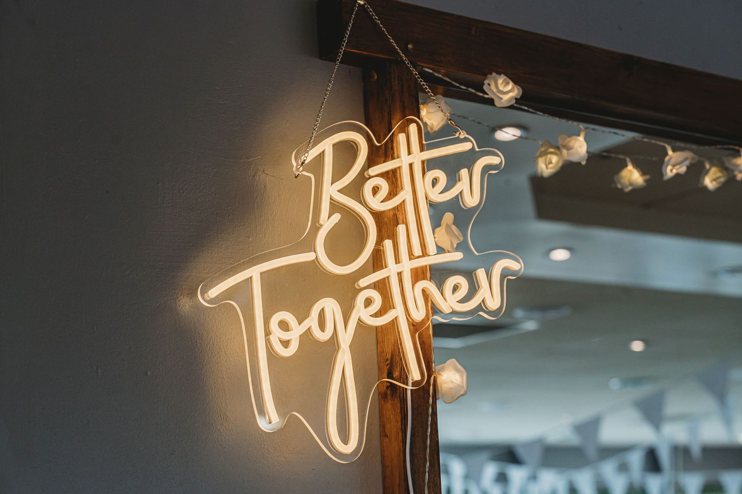 Neon sign reading 'Better Together' glows against dark background with string lights.