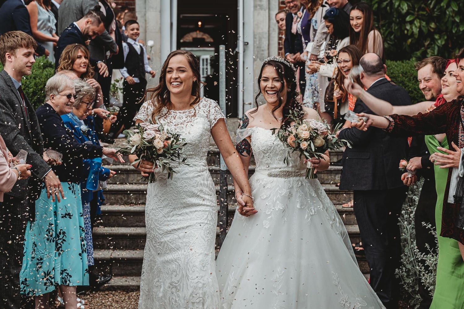 A wedding celebration on stone steps with confetti and cheering guests.