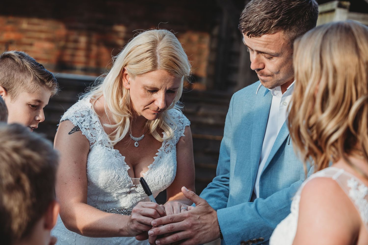 Intimate moment during wedding ceremony with guests gathered around.