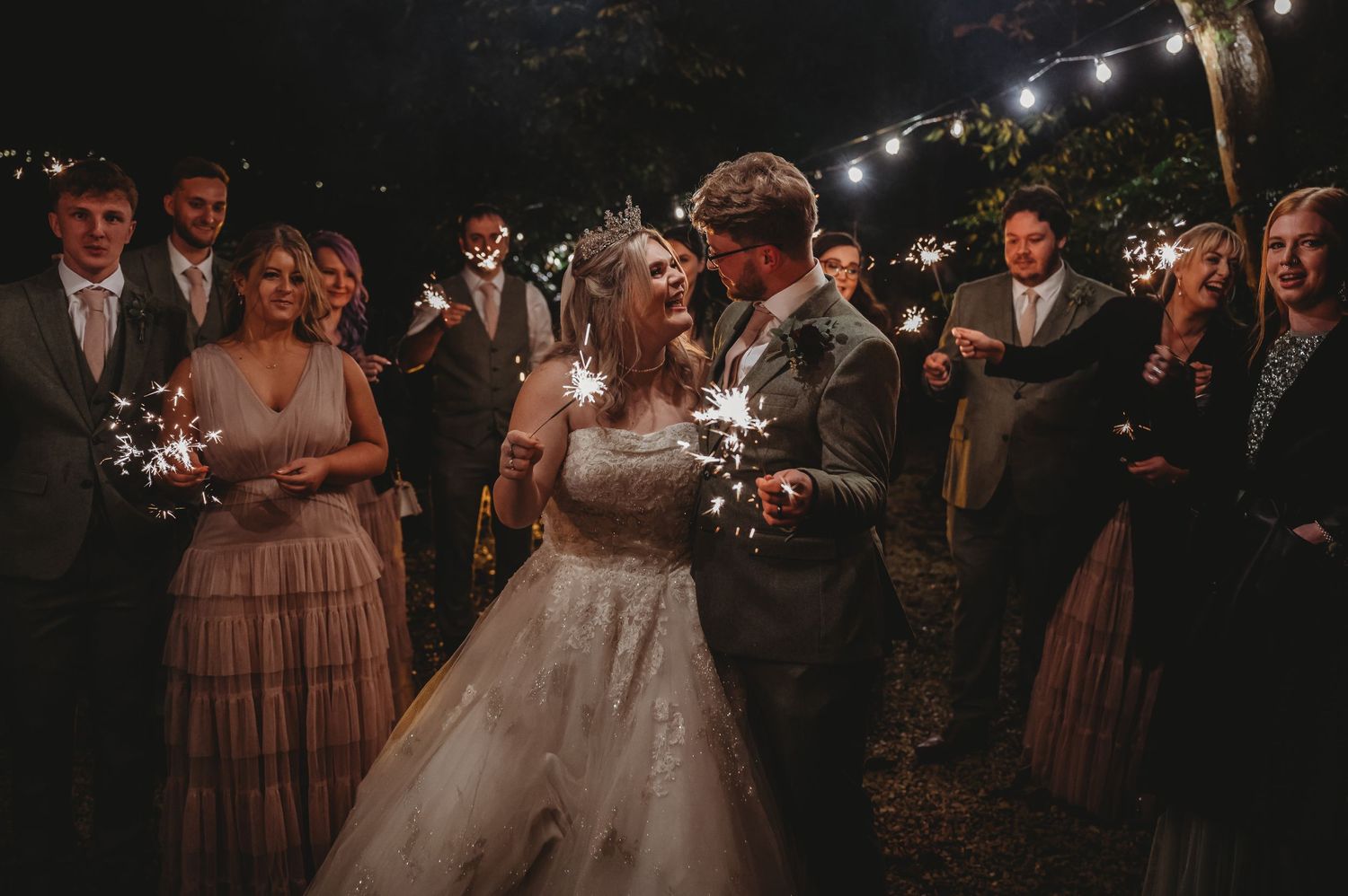 A nighttime wedding celebration with sparklers creating a magical atmosphere.